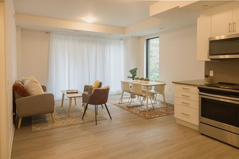 a living room and kitchen with a table and chairs